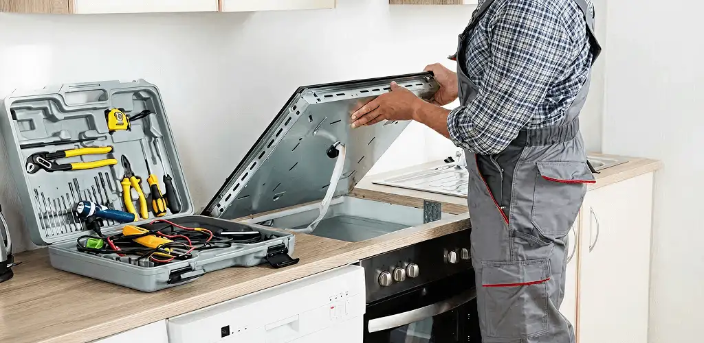 Handyman repairing a cooktop and checking wiring connections in Chula Vista, CA