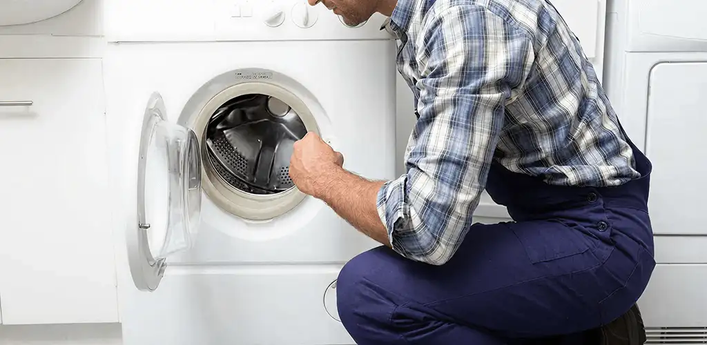 Handyman inspecting a dryer drum and internal parts for repair in Chula Vista, CA