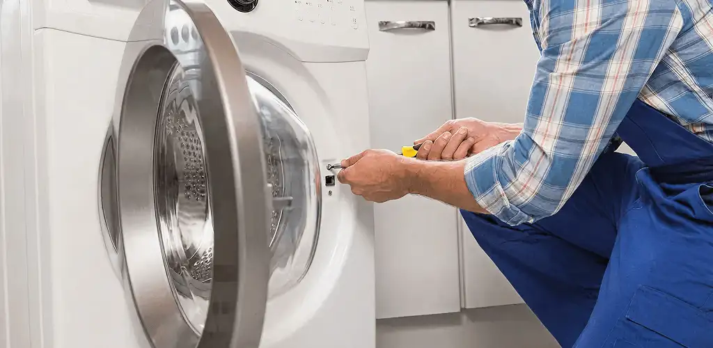Handyman repairing a clothes dryer and checking electrical connections in Chula Vista, CA