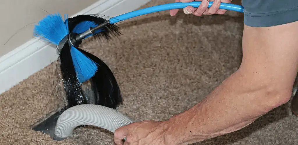 Dryer vent cleaning technician brushing lint from a vent line in Chula Vista, CA