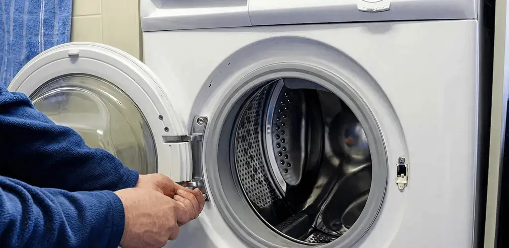 Washing machine repair handyman checking a front-load washer door and latch in Chula Vista, CA