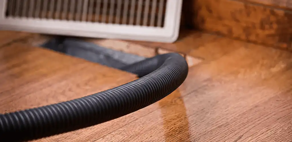 Air duct cleaning hose inserted into a floor vent for ductwork cleaning in Chula Vista, CA