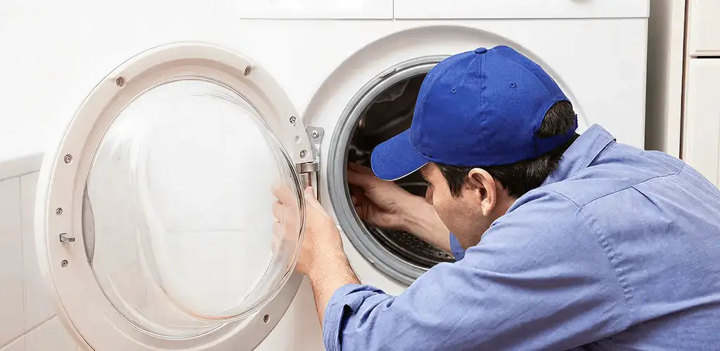 Washing machine repair handyman inspecting a front-load washer drum in Chula Vista, CA