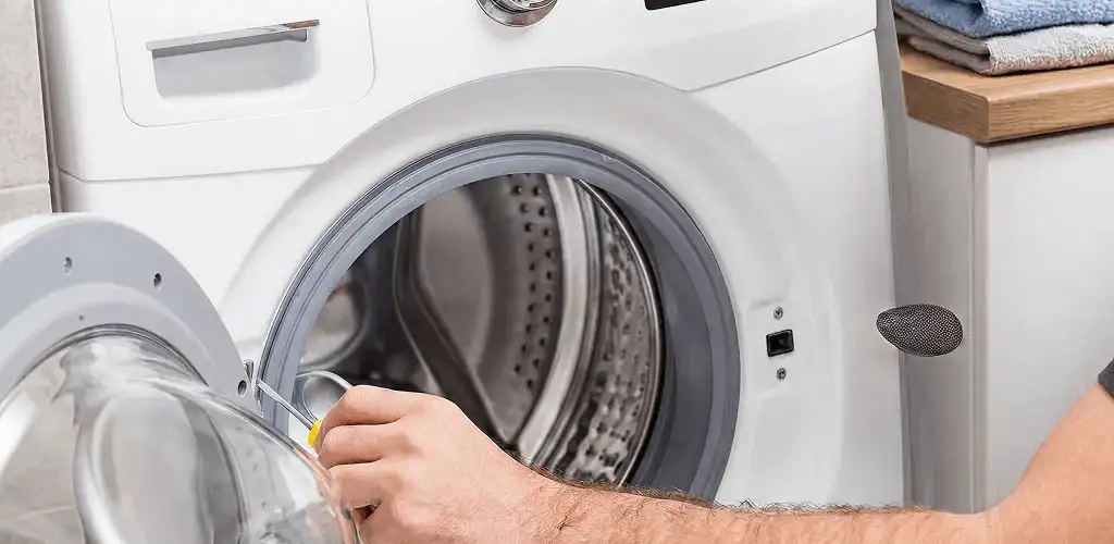 Handyman repairing a front-load washing machine and inspecting the drum in Chula Vista, CA